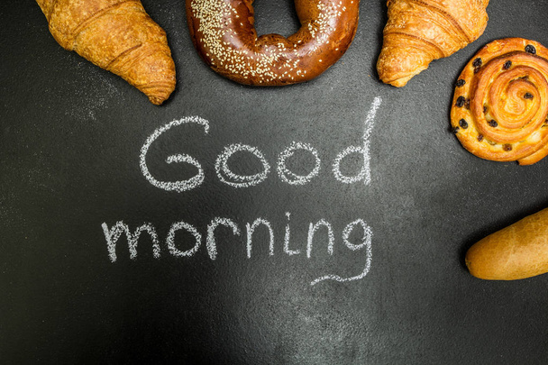 Fresh buns on a black background, the words "good morning" - Photo, Image