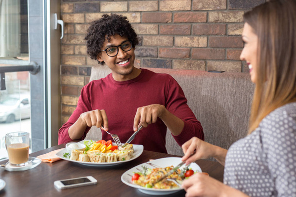 Onnellinen kaunis pari lounastaa ravintolassa hymyillen
 - Valokuva, kuva