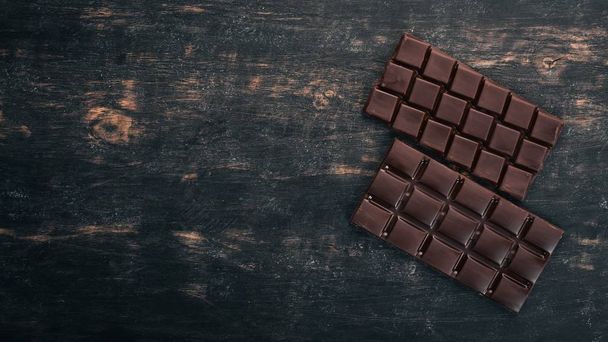 Dark chocolate on a wooden table. Top view. Copy space for text. - Foto, Bild