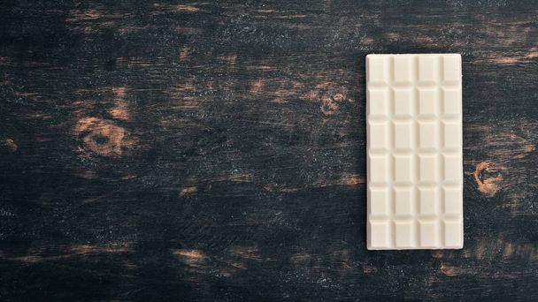 White milk chocolate on a wooden table. Top view. Copy space for text. - Photo, Image