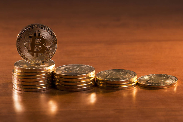 několik zlatých bitcoiny položené na dřevěný stůl. - Fotografie, Obrázek