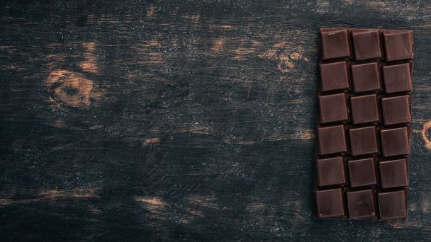 Dark chocolate on a wooden table. Top view. Copy space for text. - Foto, Bild
