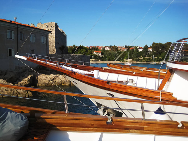 Vista attraverso più archi da barche a vela da crociera in mogano al monastero sull'isola di Krk in Croazia
 - Foto, immagini