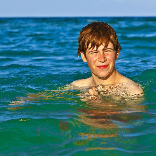 νεαρό αγόρι απολαμβάνει τη θάλασσα - Φωτογραφία, εικόνα