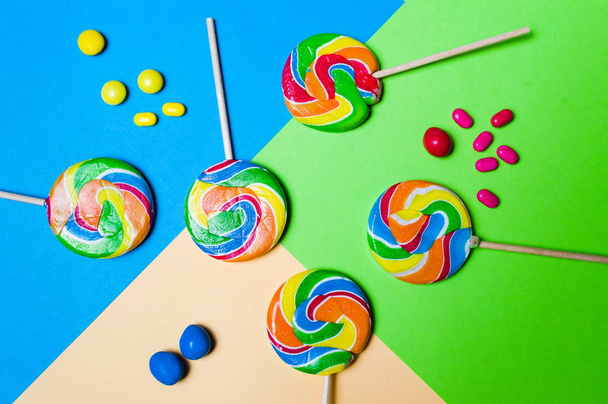 Lollipop snoepjes op kleurrijke achtergrond - Foto, afbeelding