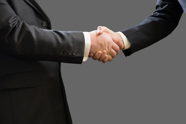 Бізнес рукостискання двох бізнесменів в костюмах ізольовані на сірому фоні
 - Фото, зображення