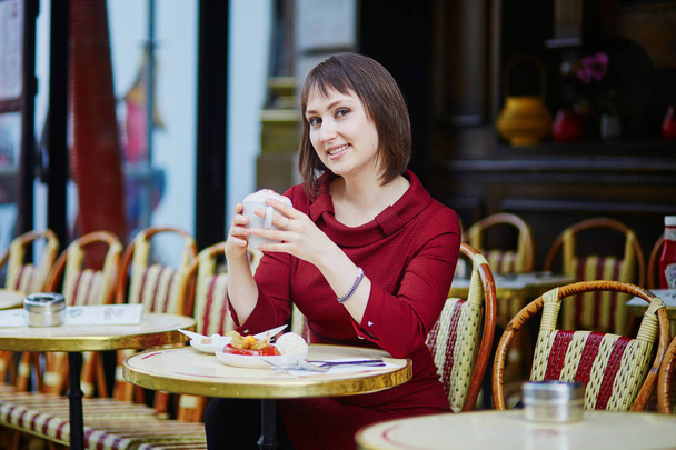 Beautiful French woman drinking coffee in outdoor cafe in Paris, France - Fotoğraf, Görsel