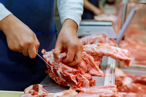 Carving raw meat. Raw meat curving on wooden background. Curving raw meat retail local market. - Photo, Image