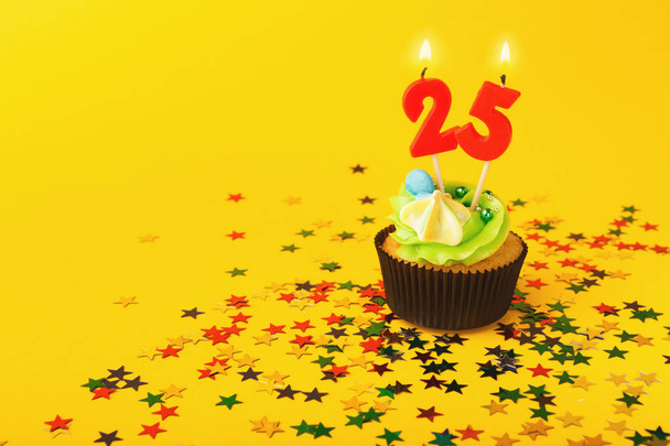 25th syntymäpäivä cupcake kynttilän ja strösseleitä
 - Valokuva, kuva