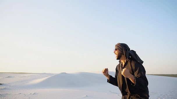 Šťastný chlap arabský, chodí přes poušť, úsměvy a těší se li - Fotografie, Obrázek