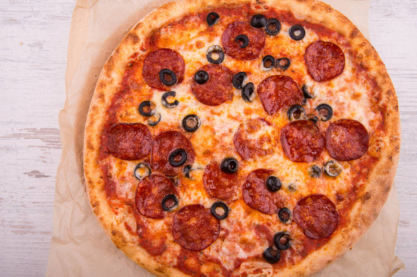 Pizza with pieces of salami and black olives - Photo, Image