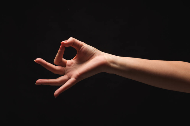 Женская рука что-то подбирает, вырезает в черном
 - Фото, изображение