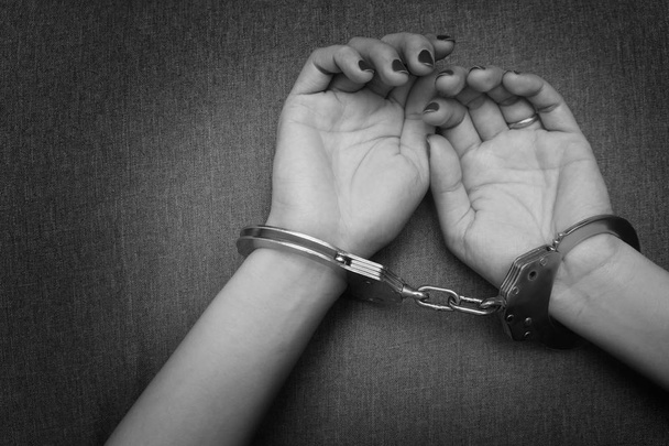 Mãos de mulher algemadas, algemas de brinquedo sexual ou prisioneiro de prisão, tom preto e branco
 - Foto, Imagem