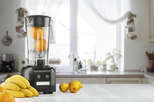 Metal food blender close-up with fresh exotic tropic fruits next to it on kitchen background with empty space - Photo, Image