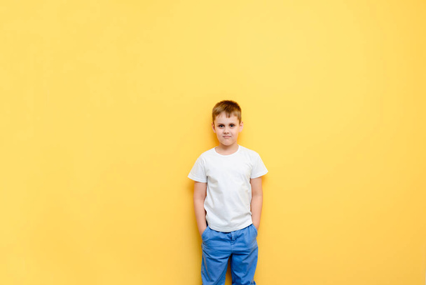 pretty boy on a background of yellow wall - Φωτογραφία, εικόνα
