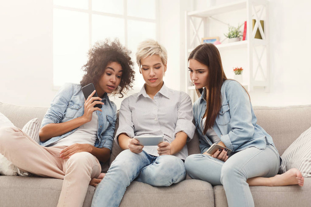 Tre amiche che usano gli smartphone a casa
 - Foto, immagini