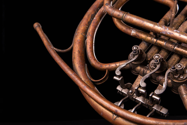 Vintage bronze pipes, valve, key mechanical elements french horn, black background. Good pattern, prompt music instrument. - Photo, Image