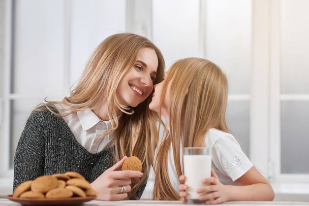 Older and younger sisters eating cookies. - Fotó, kép