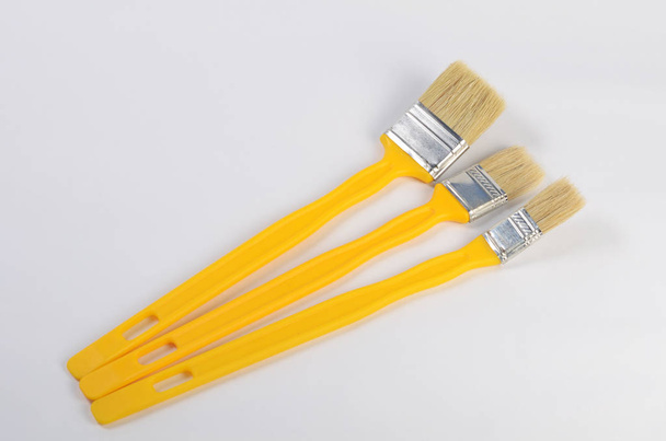 The yellow brush for painting paint - Foto, afbeelding