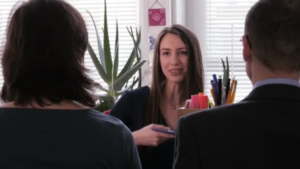 Gut gemacht - zufriedene Geschäftsfrau überreicht ihrem Team ein Klemmbrett mit einem Projekt - Filmmaterial, Video