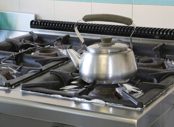 стальные чайник горшки на плите в промышленной кухне
 - Фото, изображение
