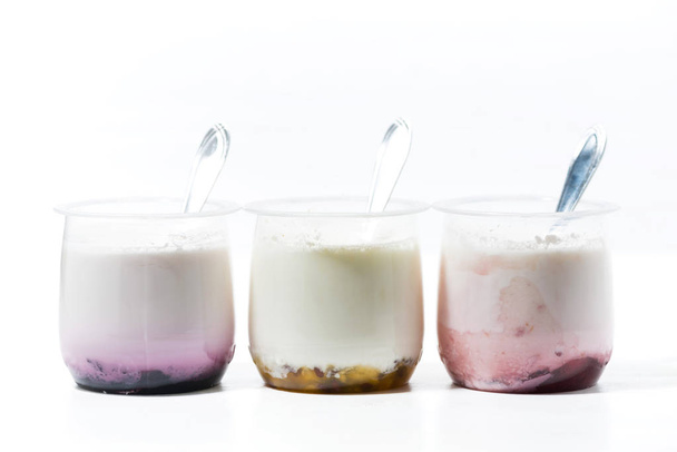 assortment of yogurts with fruit additives on white table - Foto, afbeelding