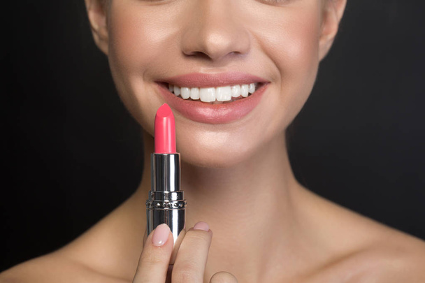Cheerful young woman is enjoying using make-up products - Photo, Image