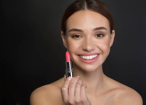 Optimistic girl is demonstrating her cosmetics - Foto, imagen