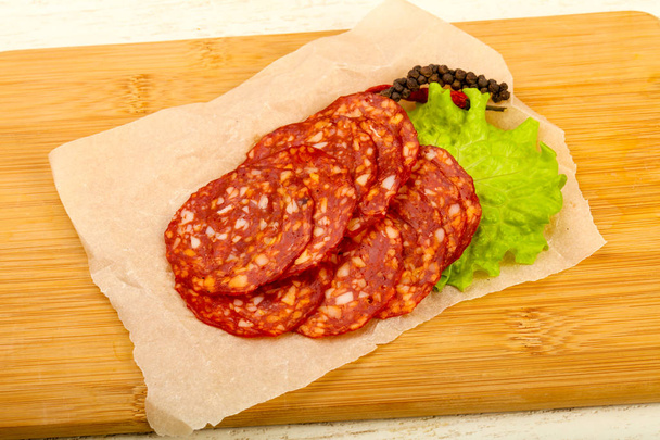 Affettato gustosa salsiccia Chorizo sullo sfondo di legno
 - Foto, immagini