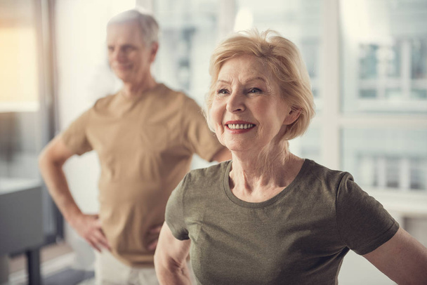 Pensionnés positifs faisant des exercices physiques à l'intérieur
 - Photo, image