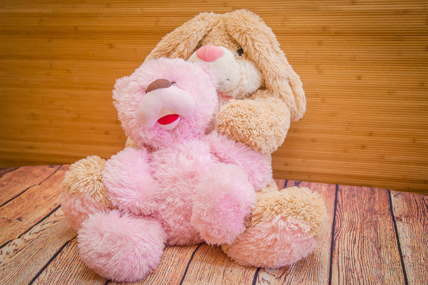 um urso rosa de brinquedo e uma estrela bege em um fundo de madeira
 - Foto, Imagem