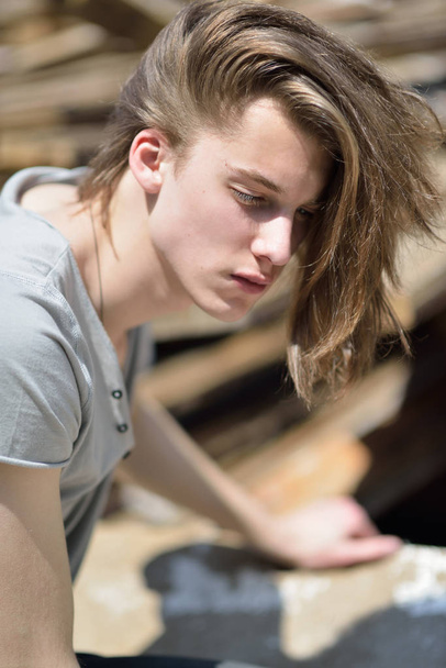 Portrait of young handsome man over wood boards, outdoor. Attrac - 写真・画像