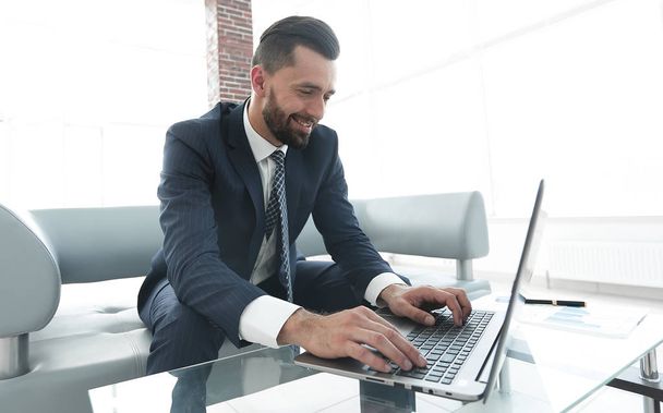 Successful man working on laptop in modern office - Foto, imagen