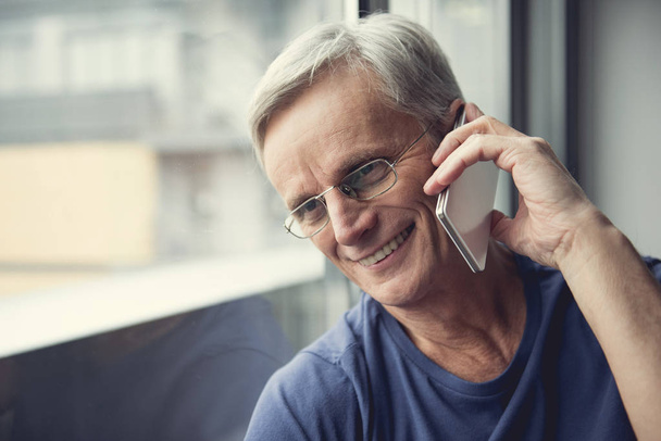 Mature man using telephone with joy - 写真・画像