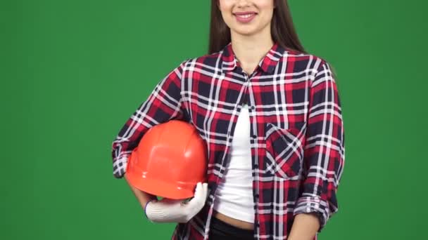 Oříznout záběr usmívající se žena inženýra ukazující thimbs drží bezpečnostní přilba - Záběry, video