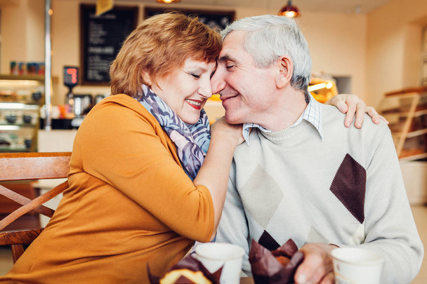 Couple de personnes âgées célébrant l'anniversaire dans le café. Couple embrasser et boire du café
 - Photo, image