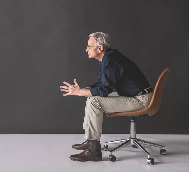 Thoughtful mature male on chair - Foto, Imagen