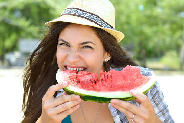 Happy young woman eating watermelon on the beach. Youth lifestyl - Fotografie, Obrázek