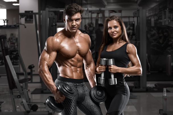 Deportiva sexy pareja mostrando músculo y ejercicio en el gimnasio. Hombre musculoso y wowan
 - Foto, Imagen