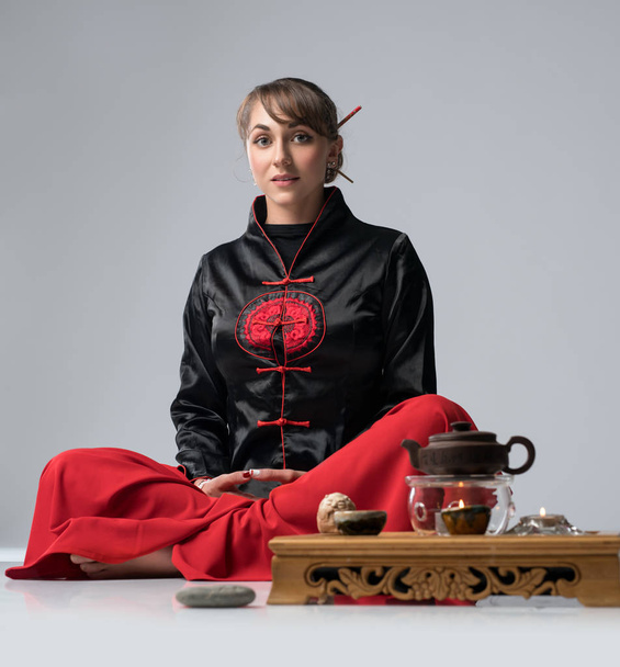 Женщина за столом накрыта для китайской чайной церемонии
 - Фото, изображение