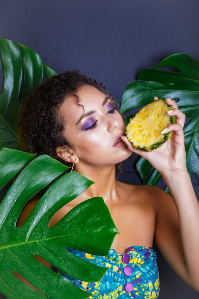 Close-up of beautiful girl with pineapple posing in tropical forest - Fotografie, Obrázek