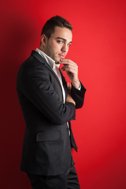 Young man portrait against red background - 写真・画像