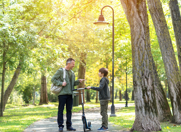 Apa és fia együtt járás őszi parkban portréja. - Fotó, kép