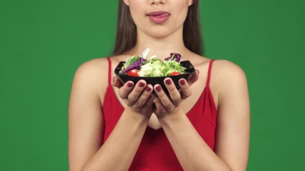Oříznout záběr nádherná sexy žena olízl rty držící misku salátu - Záběry, video