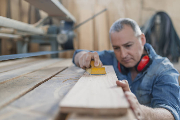 Senior man doing woodwork in carpentry. - Foto, imagen