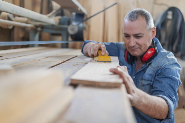 Senior man doing woodwork in carpentry. - Foto, Bild