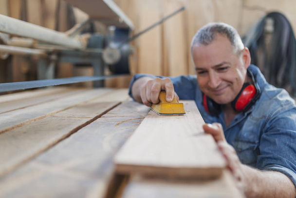 Senior man doing woodwork in carpentry. - 写真・画像