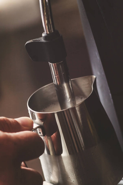Profesjonalny barman ocieplenie mleka do cappuccino. Barista usin - Zdjęcie, obraz