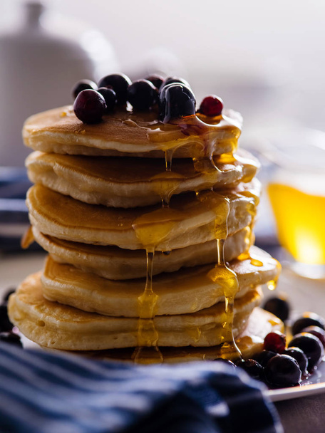 Pancakes with berries and honey on a light background - Zdjęcie, obraz