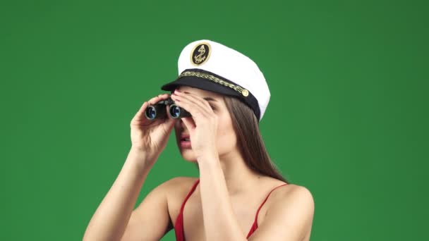 Szexi fiatal nő egy tengerész Cap keres el távcsővel, mosolyogva, vidáman - Felvétel, videó